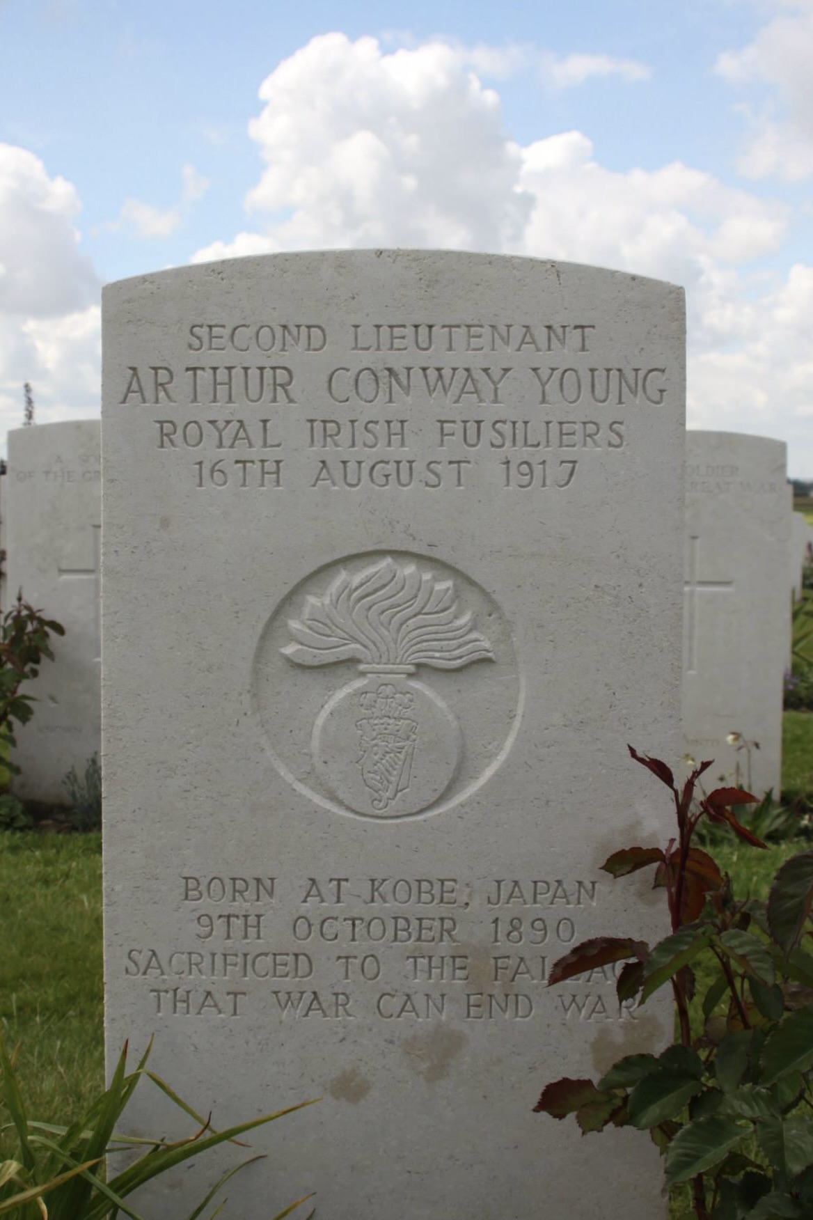 The headstone of Arthur Conway Young, the person born furthest away from the conflict in Kobe, Japan; died at age 26. The inscription reads 'Sacrificed to the fallacy that war can end war'.
