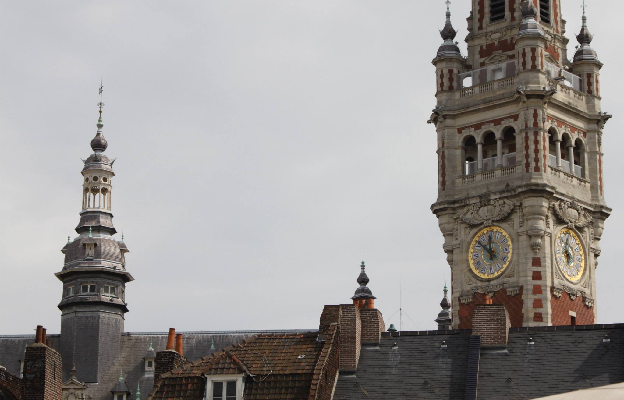 The clock tower of L'Hôtel de Ville (City Hall) looms over the rooftops in Lille.