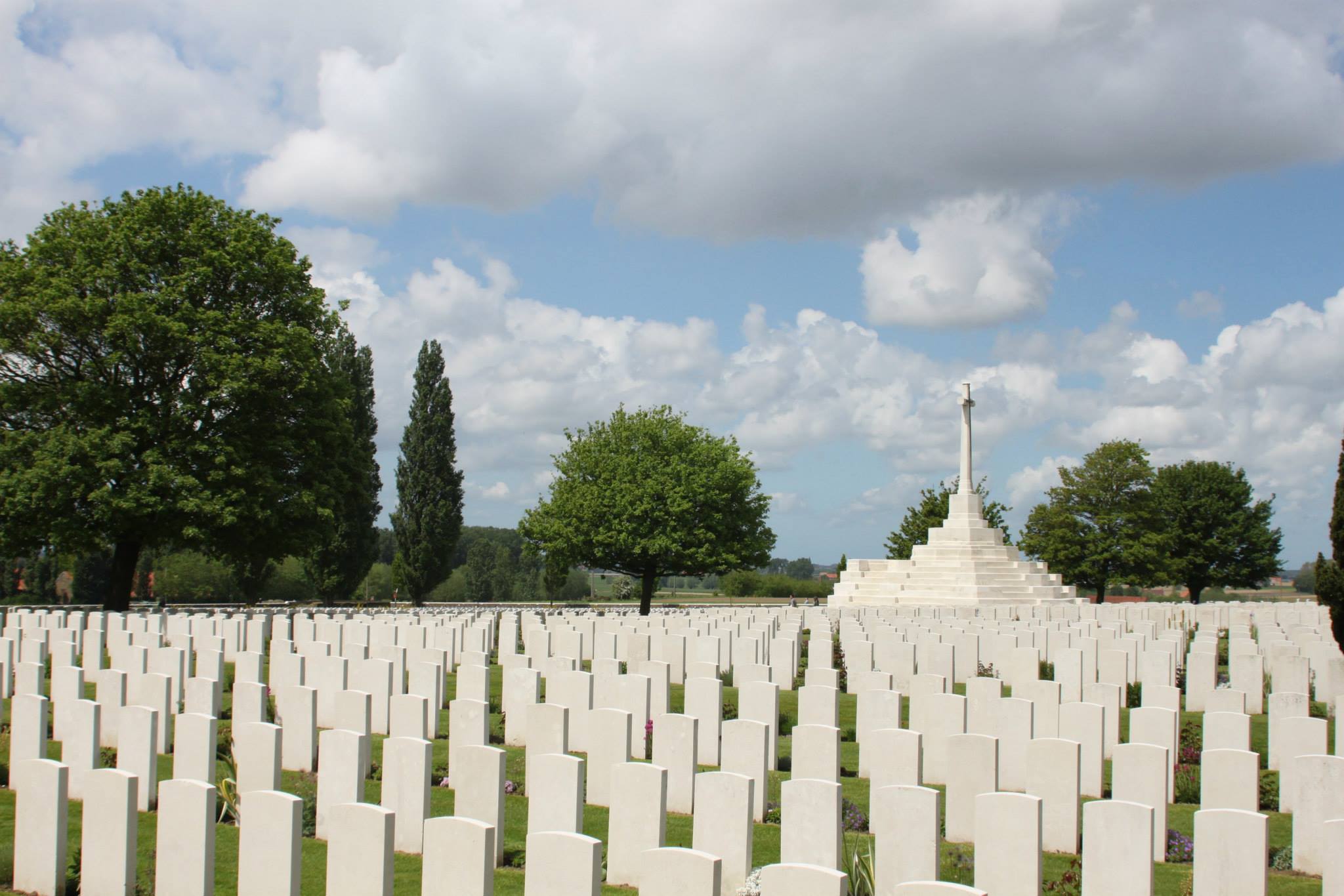 Headstones face a central monument 'The Cross of Sacrifice'.