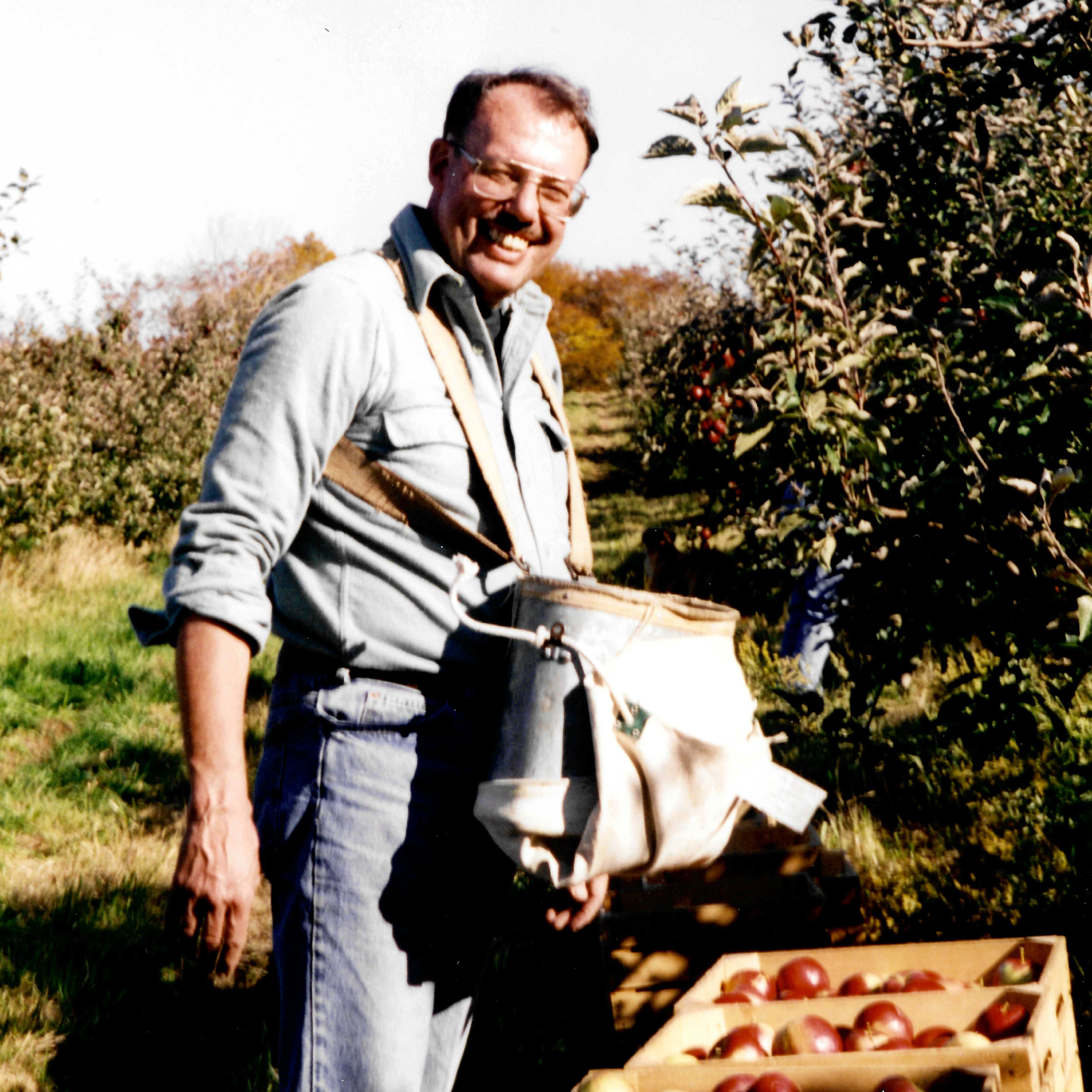My grandfather, James Watts Eckert, picking apples and smiling.